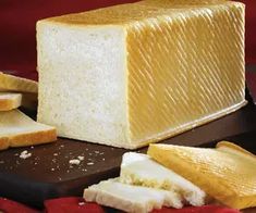 a loaf of bread sitting on top of a cutting board next to slices of bread