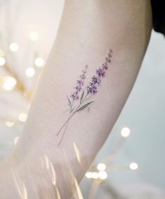 a small lavender flower tattoo on the ankle