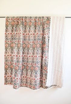 two curtains hanging on a wall next to each other in front of a white wall