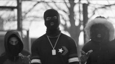 three people in black and white wearing masks