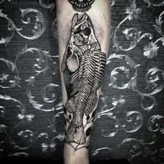 a man's leg with a fish and bones tattoo on the calf sleeve, which is