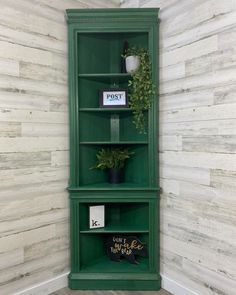 two green shelves with plants on them against a white wall