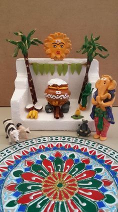 some figurines are on a table near a potted plant and other decorations