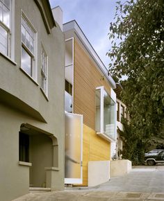 an apartment building with two cars parked on the street