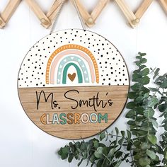 a wooden sign that says mrs smith's classroom hangs on the wall next to a potted plant