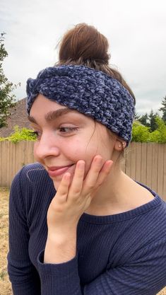 a woman wearing a knitted headband and looking at the camera with a smile on her face