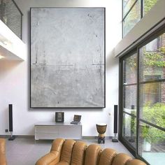 a living room with two couches and a large painting on the wall above it