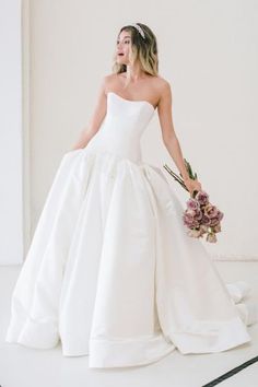 a woman in a white wedding dress holding a bouquet