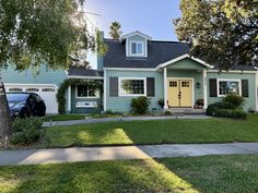 a blue house with two cars parked in front