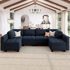 a living room with a blue sectional couch and chandelier hanging from the ceiling