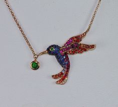 "RETAIL $3,897 ADORABLE, INCREDIBLY SWEET & COLORFUL HUMMINGBIRD!! Meet 18k \"SASSY\"... Her body is rich bright blue sapphires & ruby wings flowing into orange sapphire wing tips. Her tail matches her wing colors. She has a green garnet eye & a larger bezel set green garnet dangle from her beak. She is designed to be petite, in full flight. The 18k rose gold chain shown is included as it is attached & adjustable 16\"-18\". Listing for pendant only, ring sold separately. NOTE- IN STOCK & AVAILAB Colorful Hummingbird, Bird Rings, Emerald Blue, Fancy Yellow Diamond, Gem Diamonds, Tsavorite Garnet, Green Garnet, Bird Pendant, Rose Gold Chain