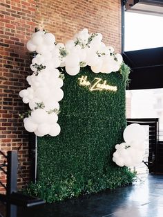 an artificial wall with balloons and greenery