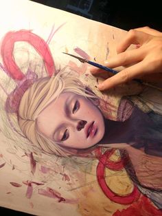 a drawing of a woman's face is being worked on with colored pencils