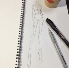 a drawing of a woman's body next to a cup of coffee and two markers