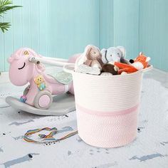 a pink basket filled with stuffed animals on top of a table