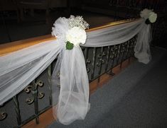 white flowers are tied to the railing with tulle and ribbons on it for an elegant touch