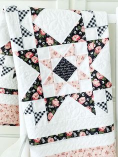 two quilts hanging from the side of a white door with black and pink flowers