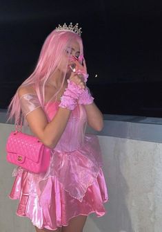 a woman dressed in pink is holding a cell phone