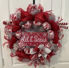 a red and white wreath with the words let it snow