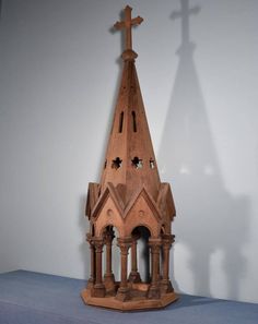 a wooden clock tower with a cross on top