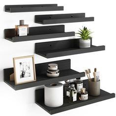 three black shelves with various items on them and a potted plant in the middle