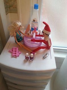 the elf is cleaning the sink in the bathroom with her doll and toothbrushes