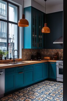 a kitchen with blue cabinets and an orange light hanging from the ceiling over the sink