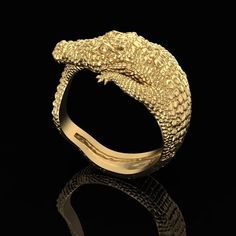 Crafted with meticulous attention to detail, this ring features a lifelike crocodile design that wraps around your finger in a graceful embrace. The textured scales shimmer in the light, showcasing the high-quality 14KT gold overlay that gives this piece its luxurious finish. Designed to captivate and impress, this ring is available in a variety of sizes to ensure a perfect fit for anyone looking to make a bold fashion statement. To maintain its luster, we recommend keeping your crocodile compan Crocodile Jewelry, Alligator Ring, Crocodile Design, Fantasy Ring, Hip Hop Rings, Animal Ring, Leather Ring, Gothic Rings, Animal Rings