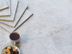 a cup of coffee and some cookies on a plate next to each other with sticks sticking out of it