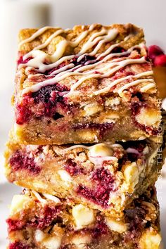 two pieces of berry crumble bars stacked on top of each other with icing