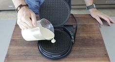 a man pours milk into a waffle iron