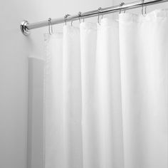 a white shower curtain hanging on the side of a wall