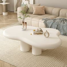 a white coffee table sitting on top of a rug in a living room next to a couch