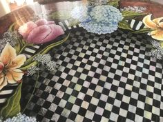 a checkered table cloth with flowers painted on it