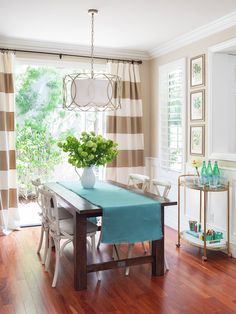 a dining room table with a blue cloth draped over it and a potted plant in the center