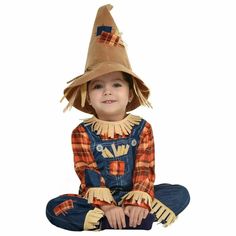 a little boy wearing a scarecrow costume sitting on the floor with his legs crossed