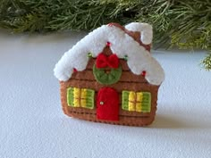 a felt house ornament hanging from a christmas tree