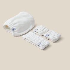 a white towel, mitts and headband are laid out on a beige background