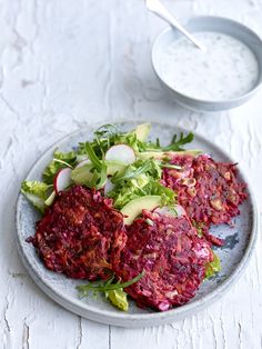 beetroot patties on a plate next to a bowl of yogurt