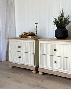 two white dressers sitting next to each other on top of a wooden floor