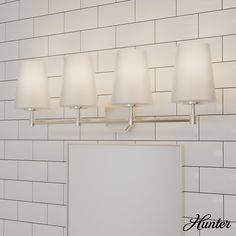 a bathroom vanity light with four lamps on it and a mirror in front of the wall