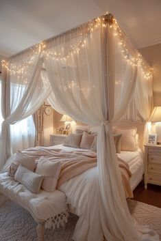 a white canopy bed in a bedroom with lights on the ceiling and curtains over it