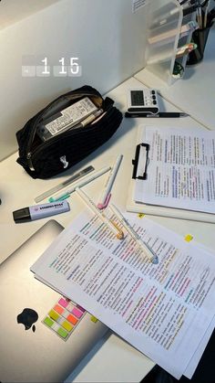 an open book sitting on top of a desk next to a cell phone and pen