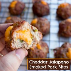 a hand holding a cheddar jalapeno smoked pork bites with cheese