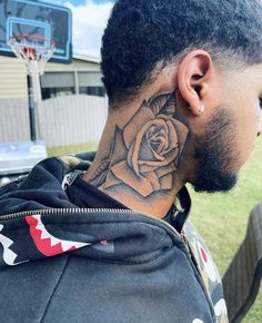 a man with a rose tattoo on his neck and behind his ear is a basketball hoop