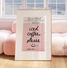 a framed poster with the words good coffee please on it in front of a pink couch