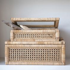 three wicker baskets stacked on top of each other, one with a bird perched on it