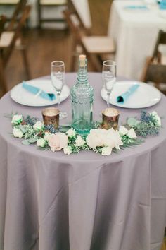 the table is set with flowers and candles for an elegant wedding reception or special event