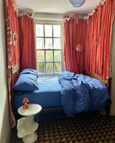 a bed sitting under a window in a bedroom