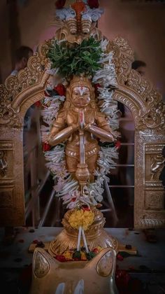 the statue is surrounded by flowers and other decorations